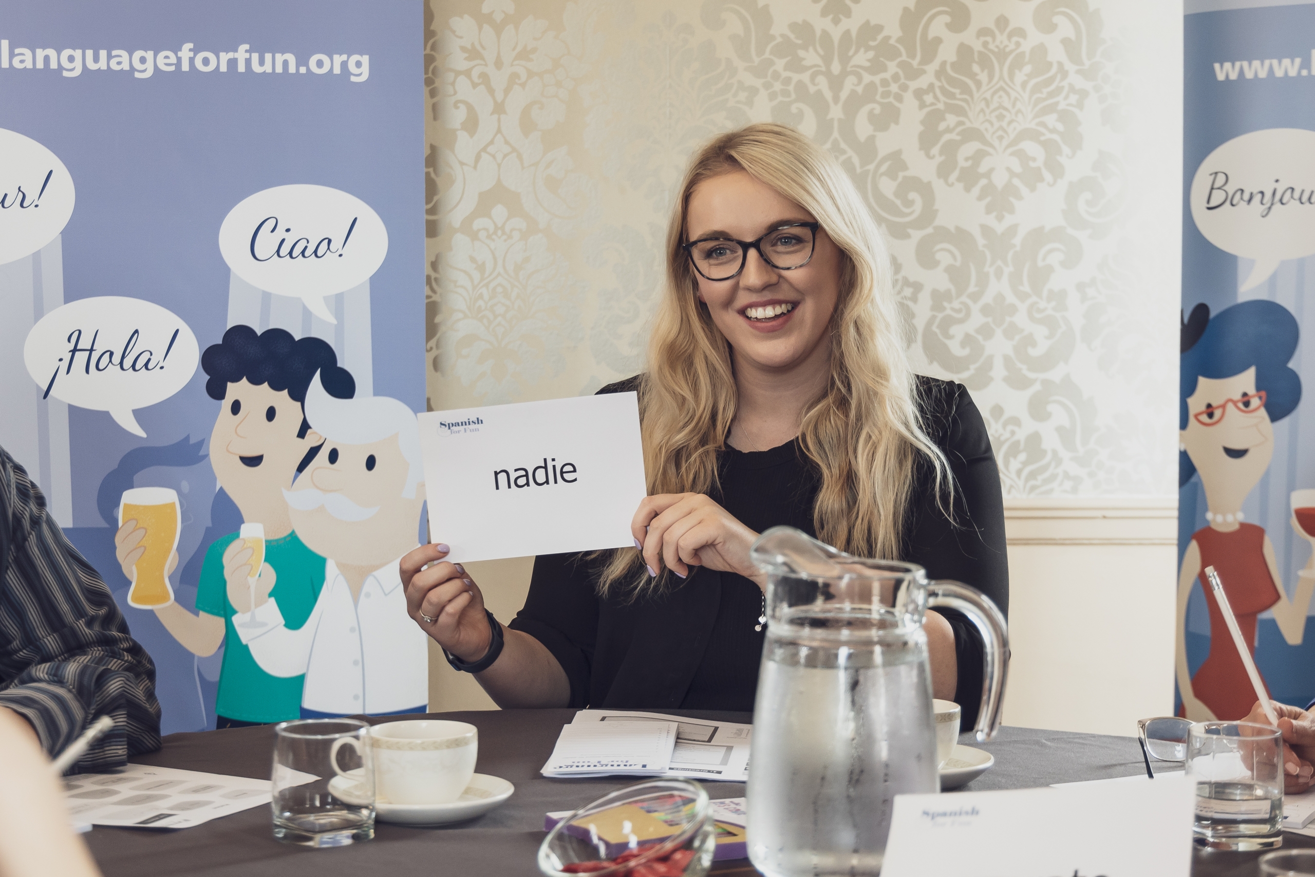 Franchisee Megan Haycock holding up a flashcard that says 'nadie.'